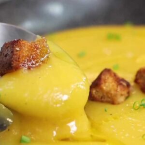 Prato com o creme de mandioquinha e alguns croutons.